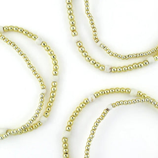 Tatum Starter Stack of gold beaded bracelets with white accents